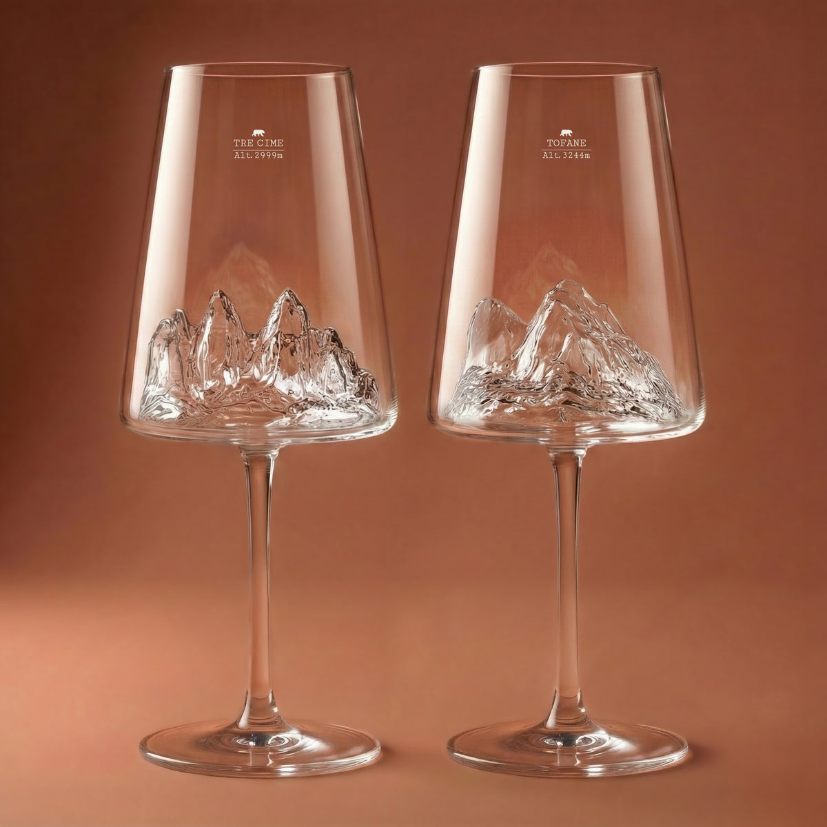 Two empty wine glasses with the Tofane and Tre Cime di Lavaredo peaks rising from the base